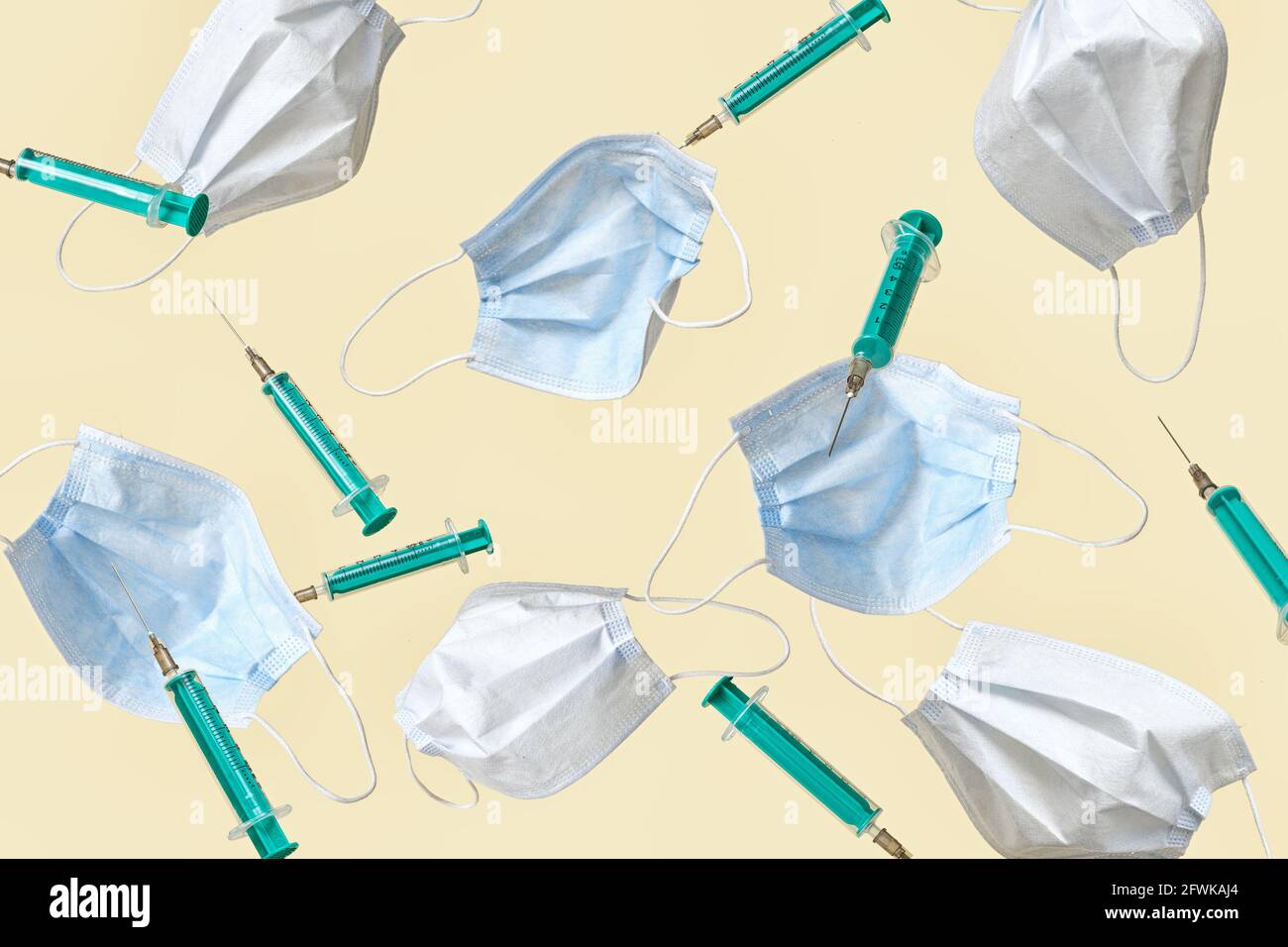 Falling protective face masks and syringes of injections or vaccinations against coronavirus or covid-19 during a pandemic. Minimal modern concept of Stock Photo