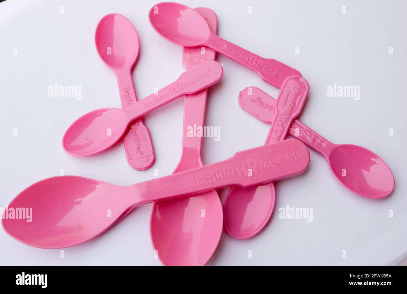 Lahore, Punjab, Pakistan - April 2, 2021: Pink Plastic spoons from Baskin Robbins on a white background Stock Photo