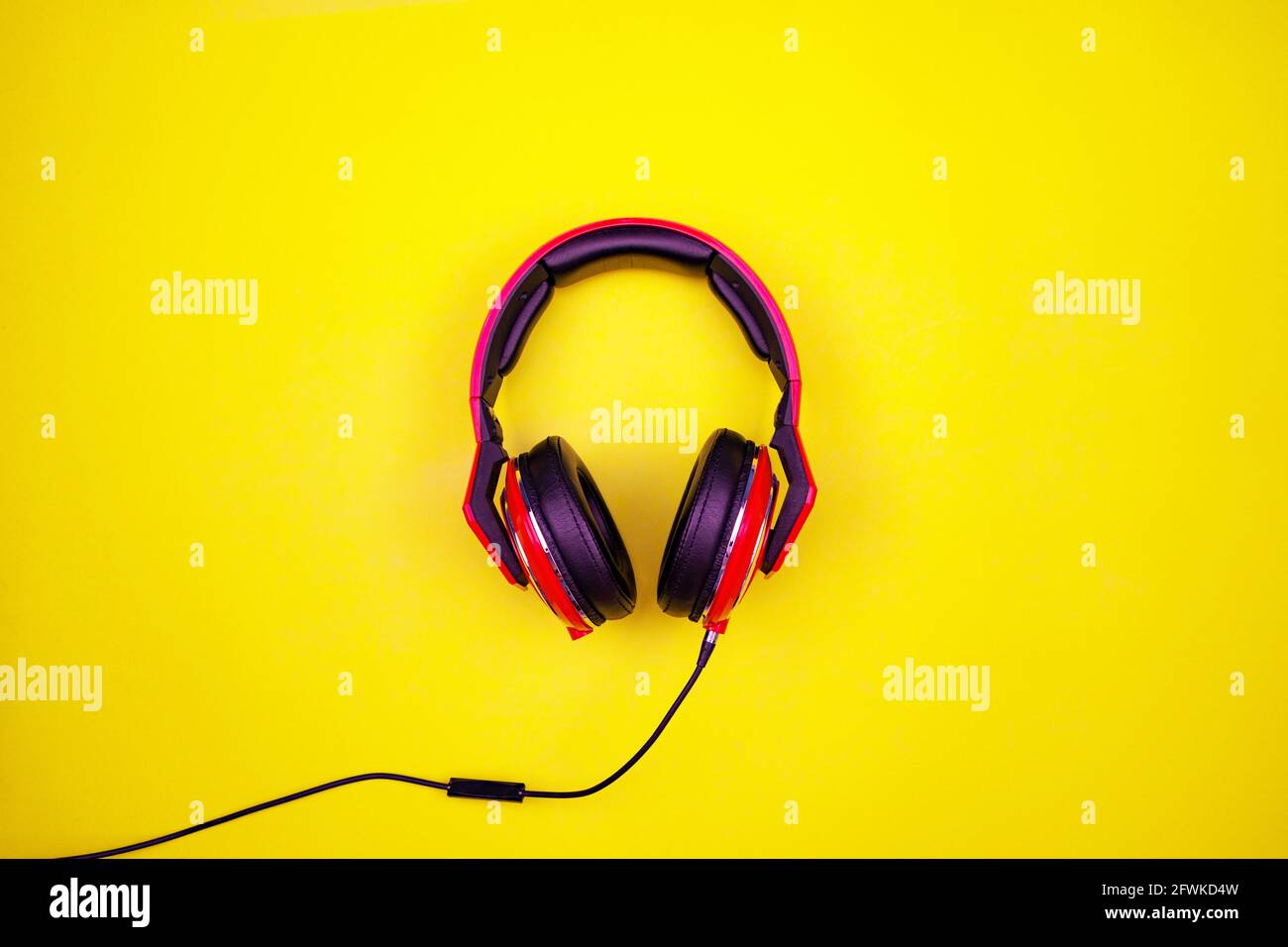 Top view of red headphone on light yellow paper background Flat Lay minimal Top down Flat lay wireless Headphones object Studio shot. Stock Photo
