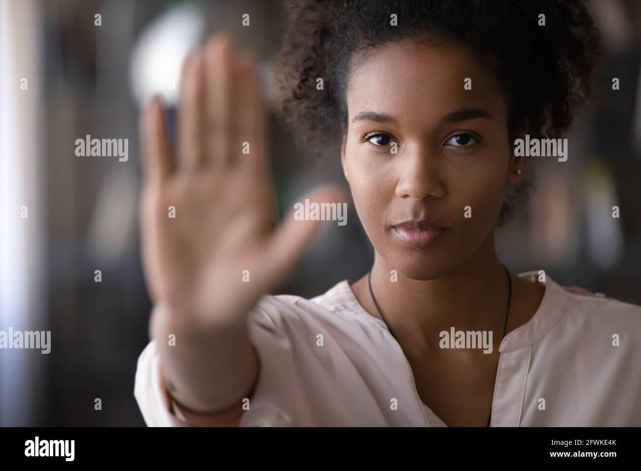 Confident african young woman showing stop signal. Stock Photo