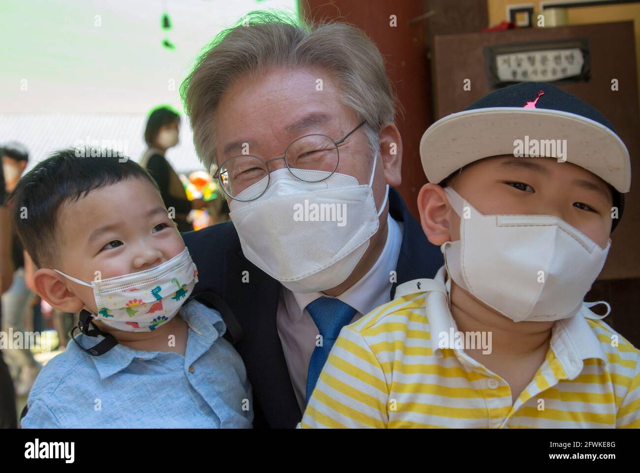 Namyangju, South Korea. 19th May, 2021. Lee Jae-Myung (C), South Korea's Gyeonggi Governor, poses for a photo with children after attending a ceremony to celebrate Buddha's birthday at Bongseonsa temple. Lee Jae-Myung is the current front-runner among the ruling Democratic Party's prospective presidential candidates. South Korea's next presidential election is slated for March 9, 2022. Credit: Jaewon Lee/SOPA Images/ZUMA Wire/Alamy Live News Stock Photo