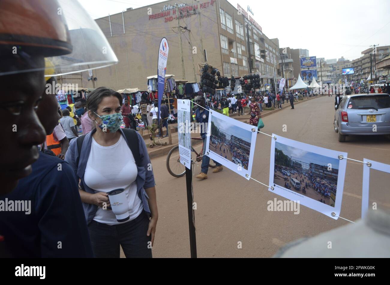 Kampala, Uganda. 23rd May, 2021. People look at displayed photos on a