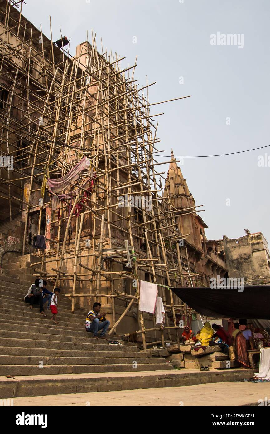Repair work on a temple using bamboo scaffold on the bank of the River Ganges, Varanasi, India. Stock Photo