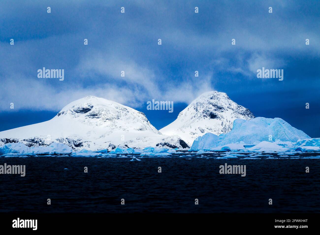 Drifting clouds and snowy mountains, Antarctica. Stock Photo