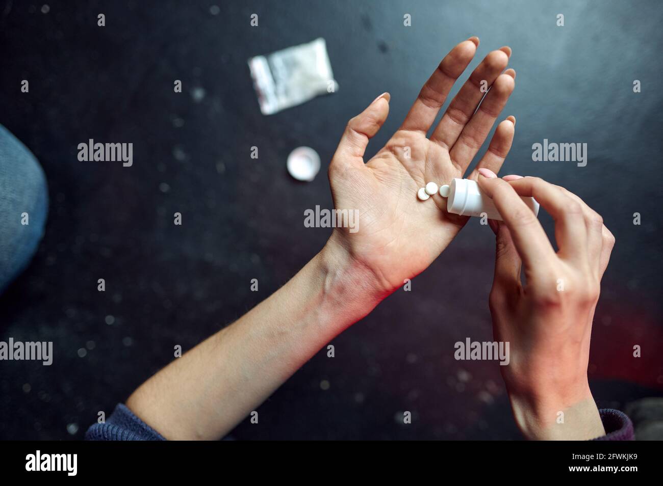 Drug addict woman holds pills, junkie concept Stock Photo