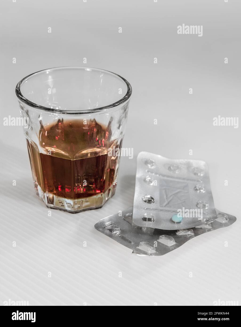 A glass of alcoholic drink and medicines. Stock Photo