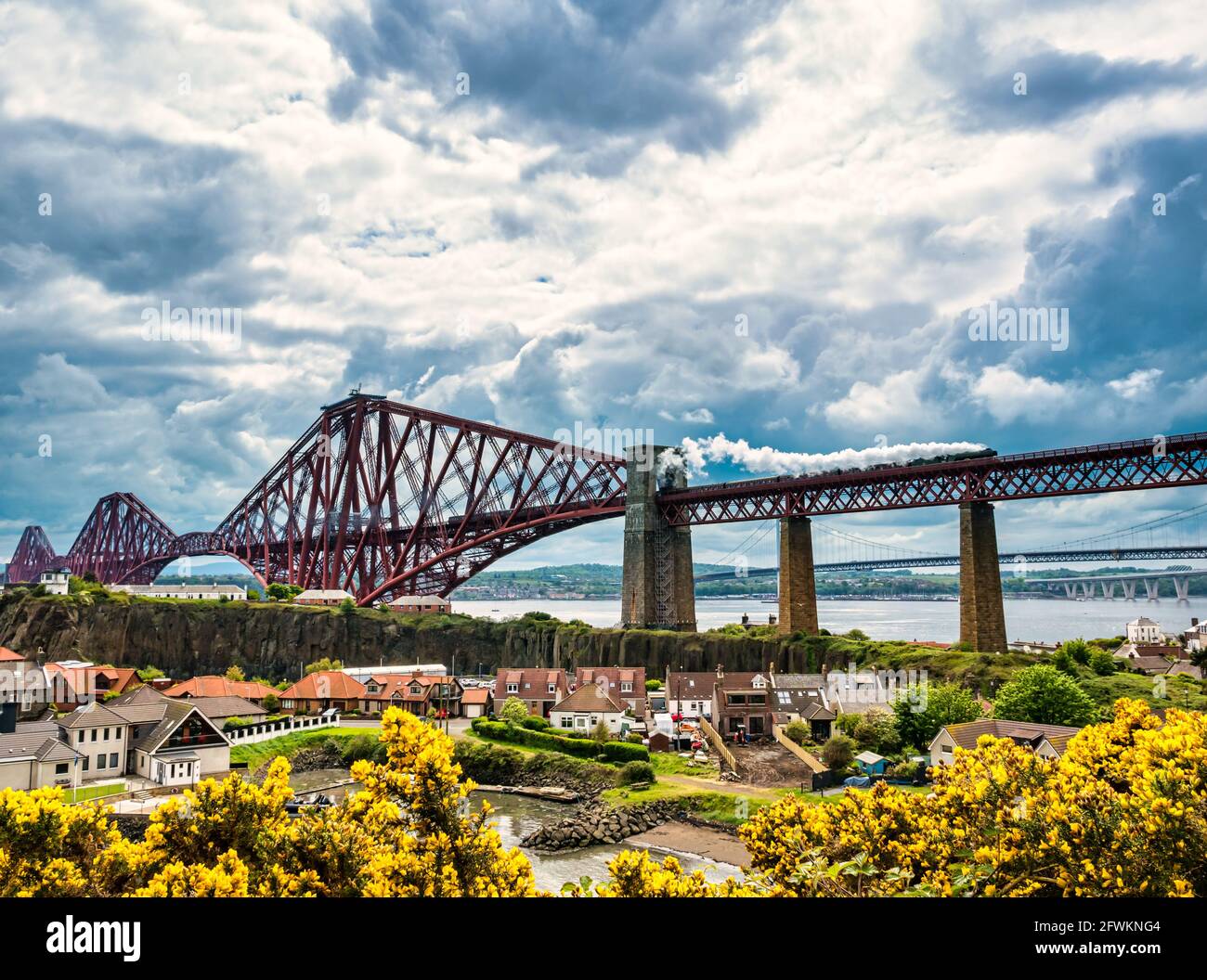 Flying Scotsman steam train crossing the iconic Forth Rail Bridge on its way towards Fife seen from North Queensferry, Scotland, UK Stock Photo