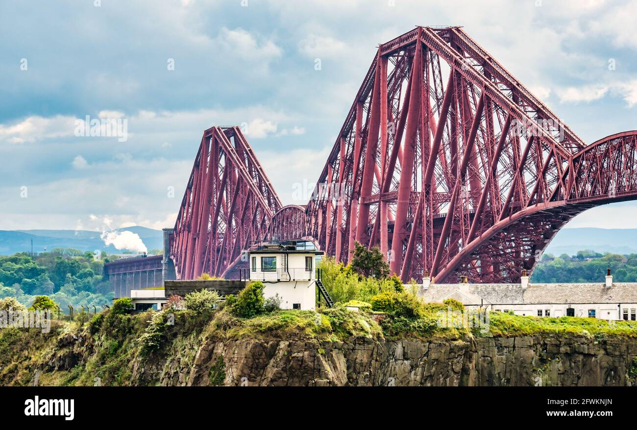 Flying Scotsman steam train crossing the iconic Forth Rail Bridge on its way towards Fife seen from North Queensferry, Scotland, UK Stock Photo