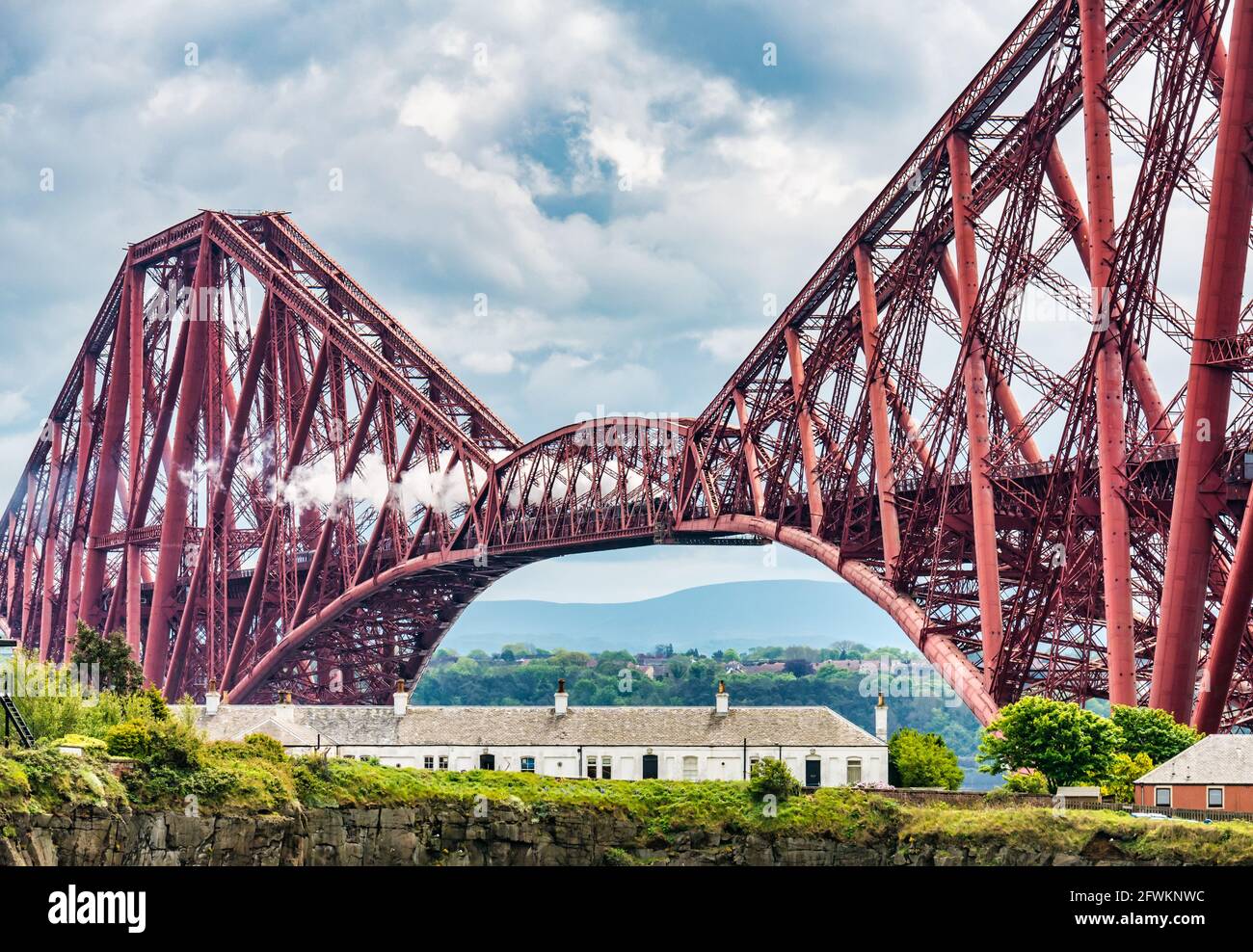 Flying Scotsman steam train crossing the iconic Forth Rail Bridge on its way towards Fife seen from North Queensferry, Scotland, UK Stock Photo