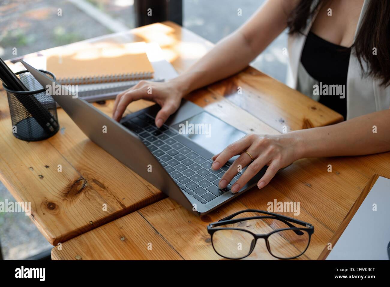 Close up females hand typing on laptop computer keyboard at home office Stock Photo
