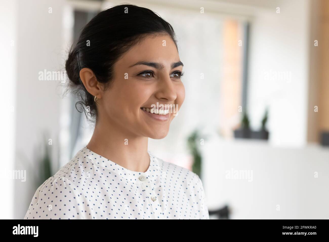 Three quarter portrait of smiling confident Indian businesswoman in office Stock Photo