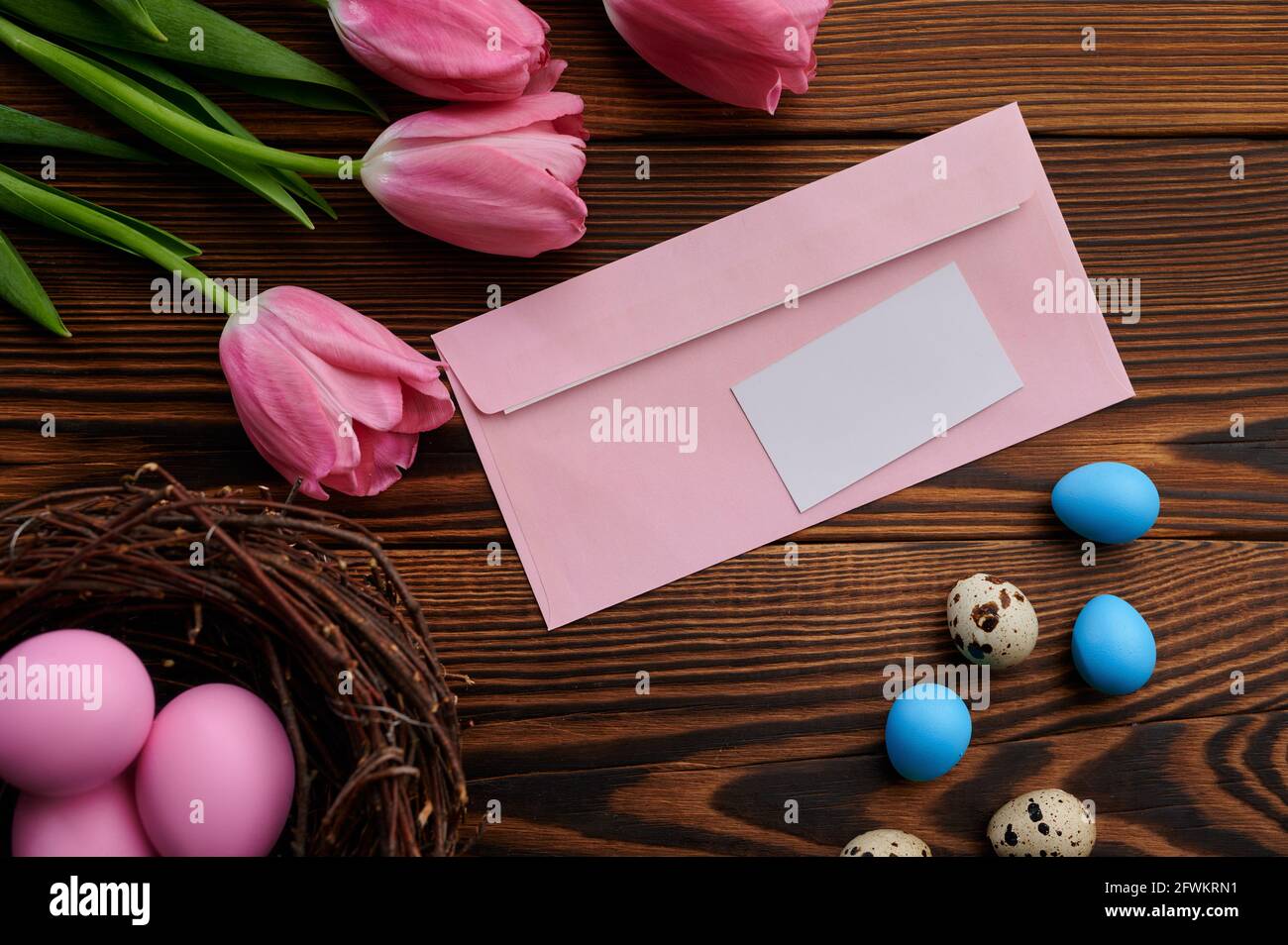 Pink tulips, easter eggs and greeting envelope Stock Photo