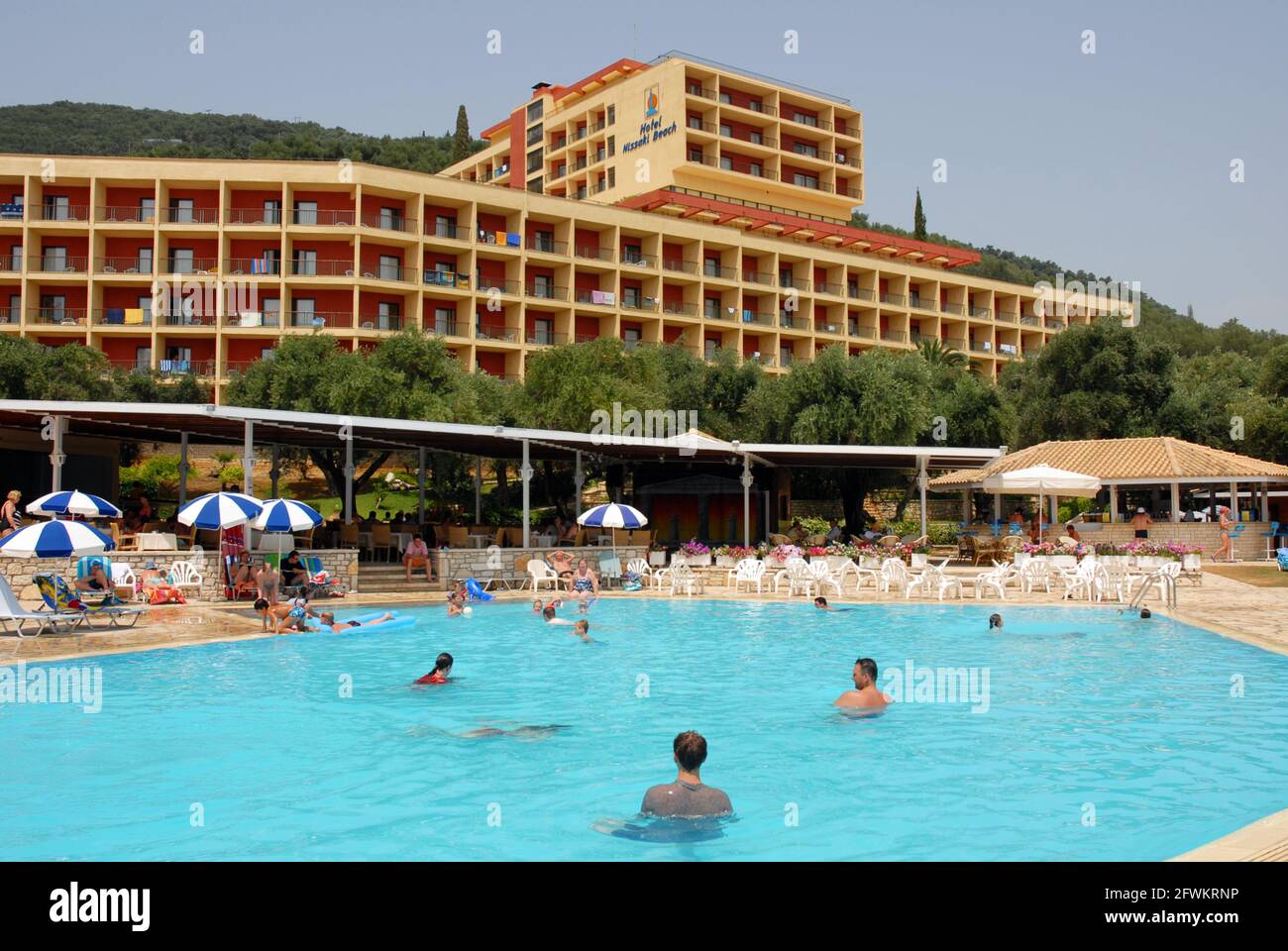 People enjoying a casual swim in the hotel pool, Nissaki Beach, Corfu, Greece Stock Photo