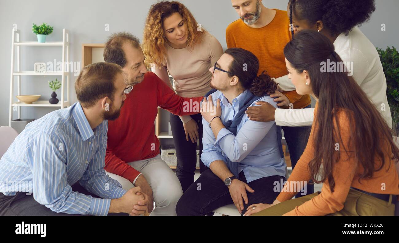 Diverse multiethnic people psychological giving support embracing teammate Stock Photo