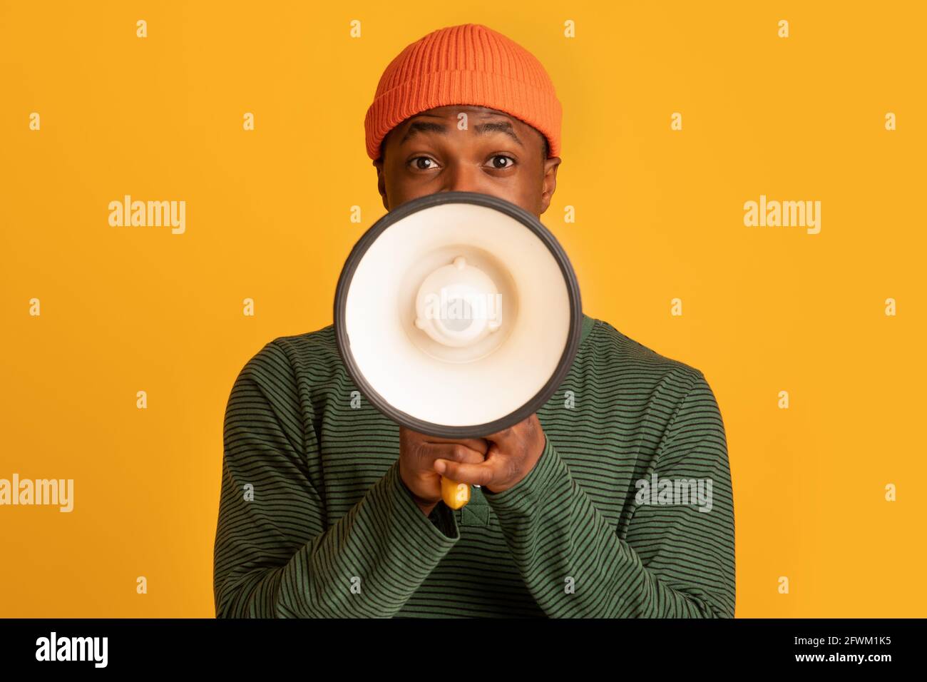 Portrait Of Young Black Hipster Guy With Loudspeaker In Hands Making Announcement Stock Photo