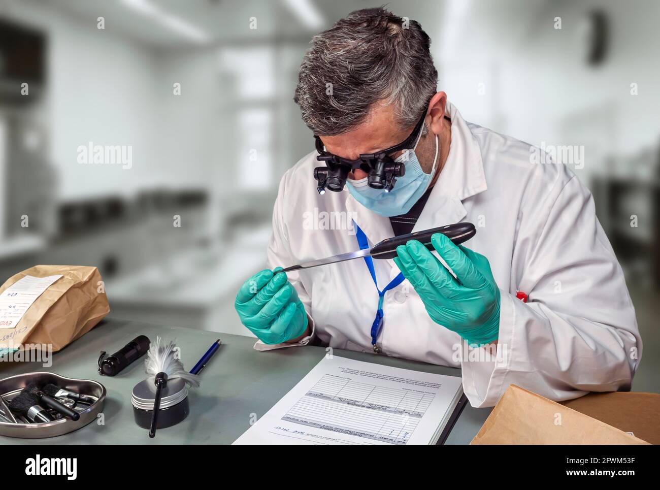Forensic police analyse knife used in murder at crime lab with magnifying glasses, concept image Stock Photo