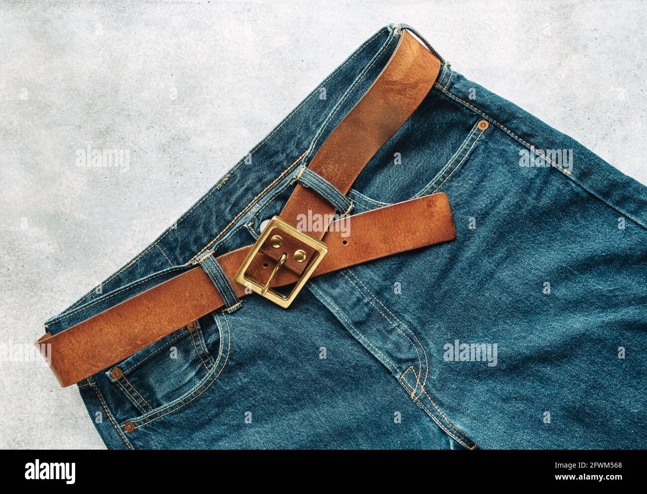 Blue mens denim pants, jeans, with a leather belt, fashion clothing concept. View from above with copy space Stock Photo