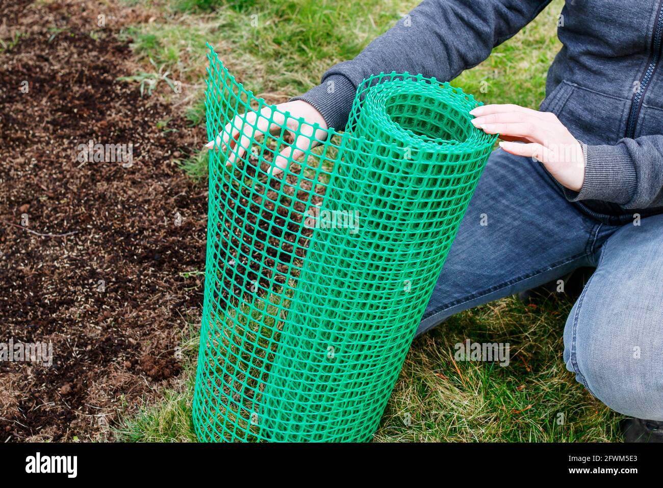 A woman holds a plastic net that is useful in gardening. Garden hobby Stock Photo