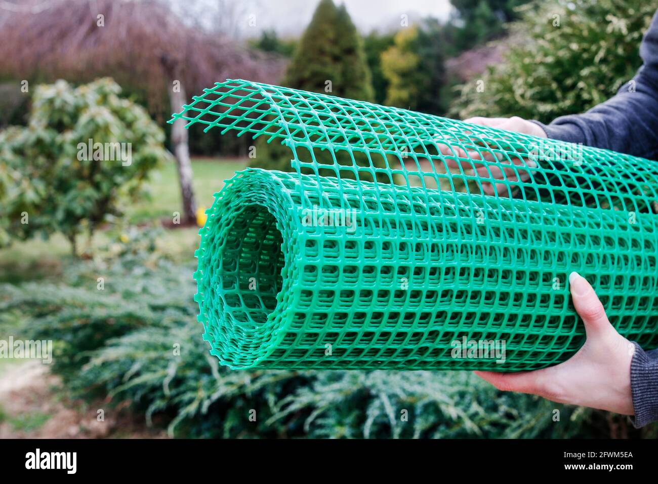 A woman holds a plastic net that is useful in gardening. Garden hobby Stock Photo