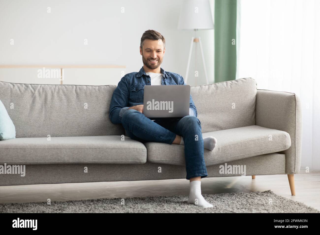 Handsome bearded man using laptop and smiling Stock Photo