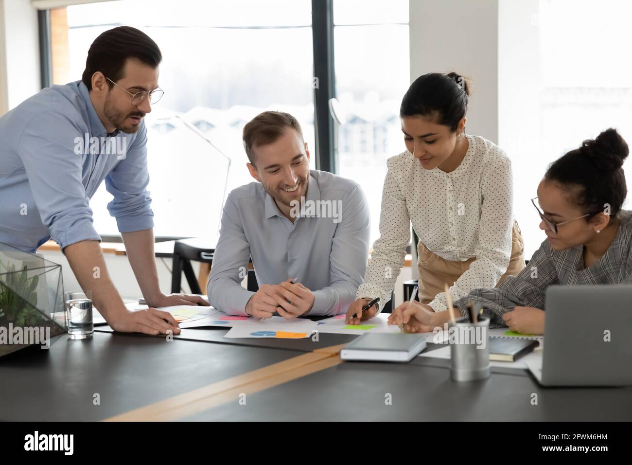 Focused diverse colleagues employees team working with documents ...