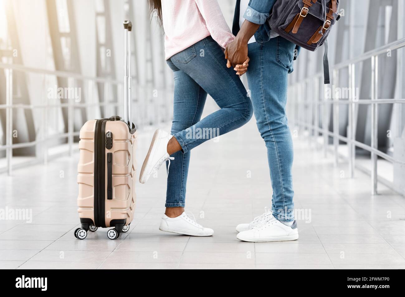 Cropped Shot Of Black Couple Holding Hands While Standing In Airport Terminal Stock Photo