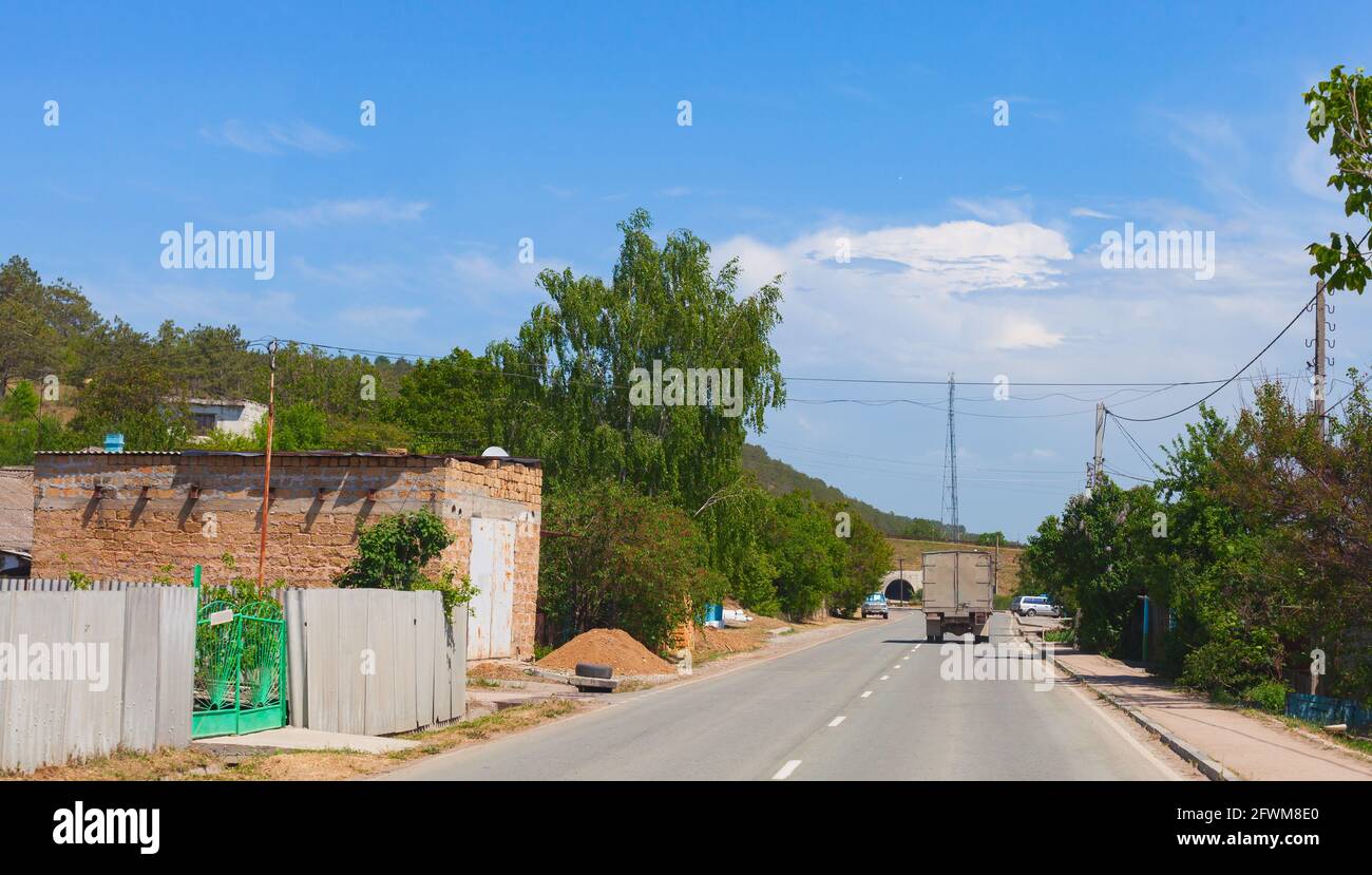 Rural road perspective with trucks and cars. Crimean road trip photo on a sunny summer day Stock Photo
