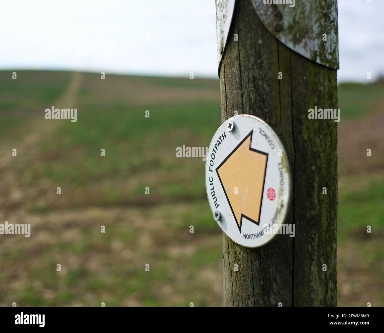 Sign on post directing to public footpath on farmland. Stock Photo
