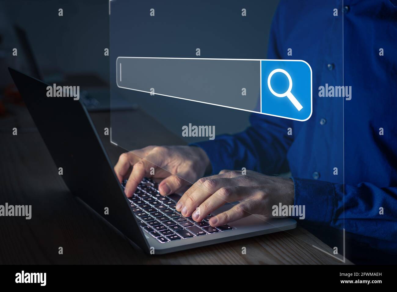 Searching on Internet with person using a browser software on laptop computer to open search engine with text bar and magnifying glass icon. Access in Stock Photo