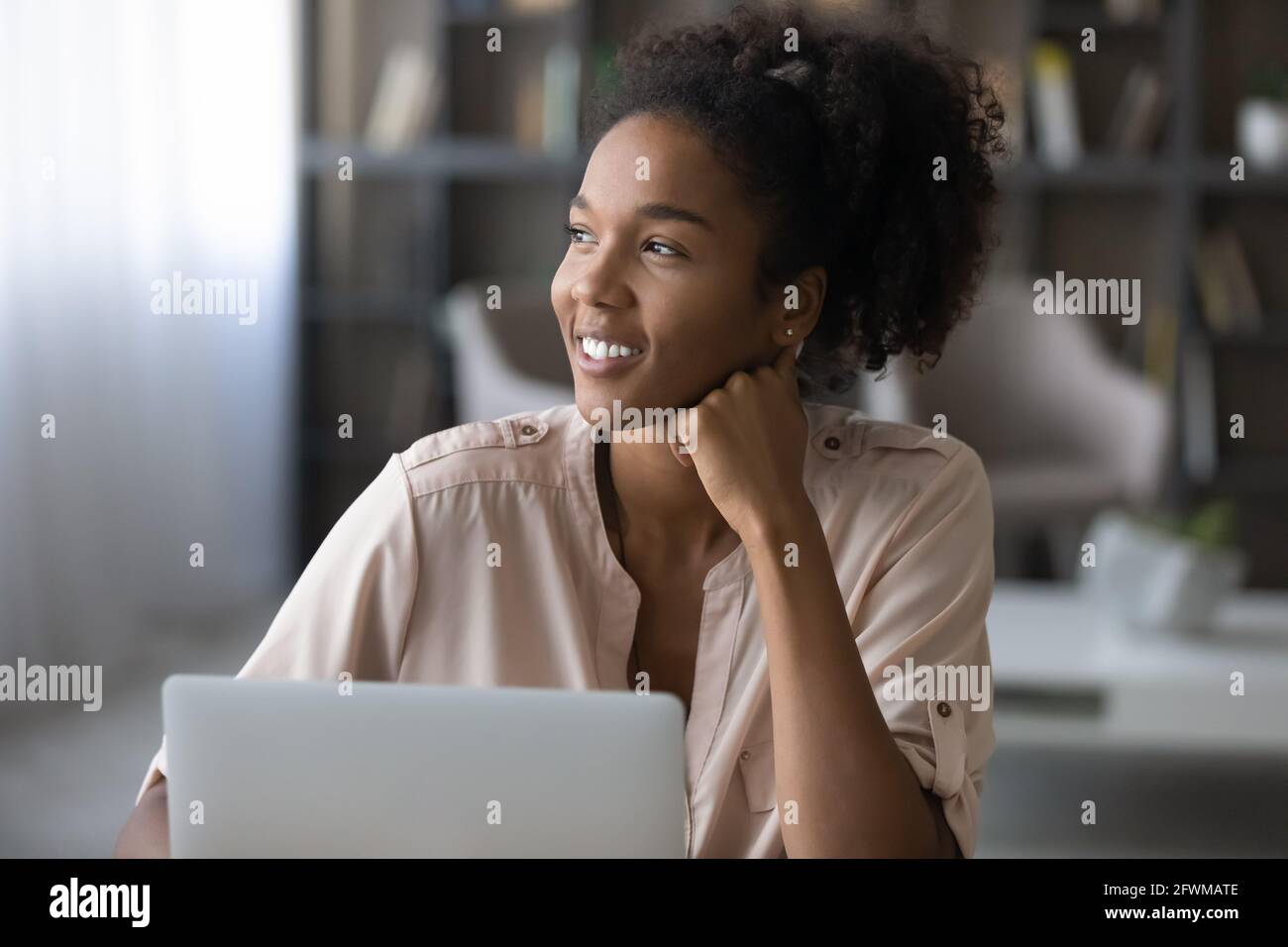 Happy beautiful african woman dreaming, working on computer Stock Photo ...