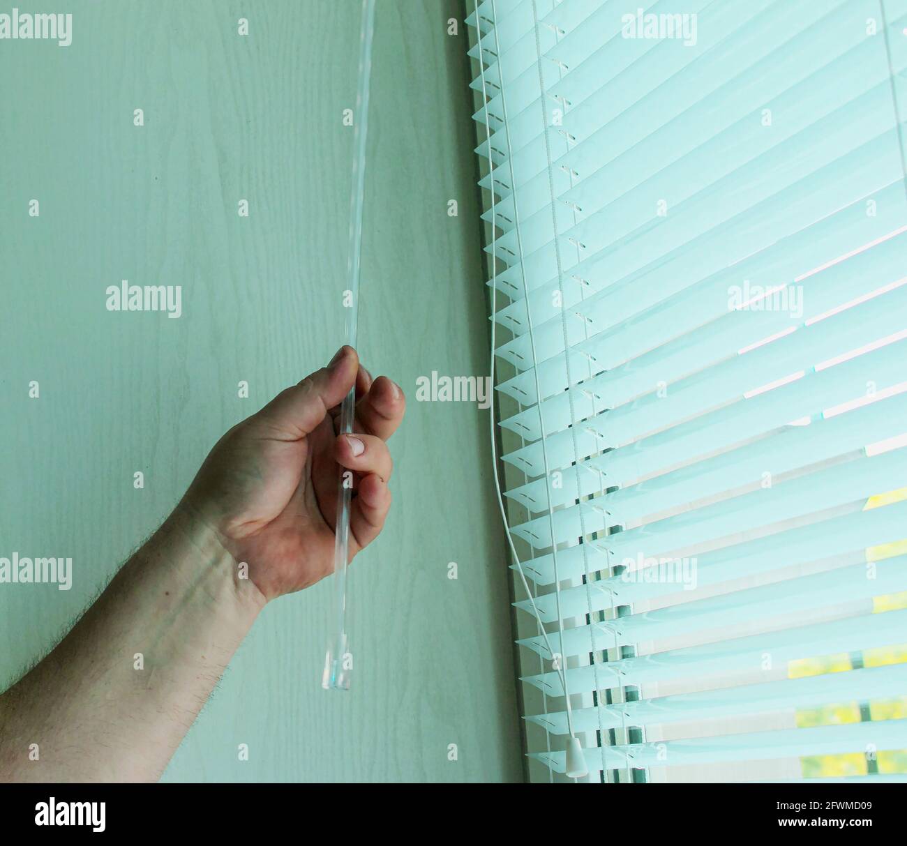 Window blinds installation process. Man testing cassette roller blinds on windows Stock Photo
