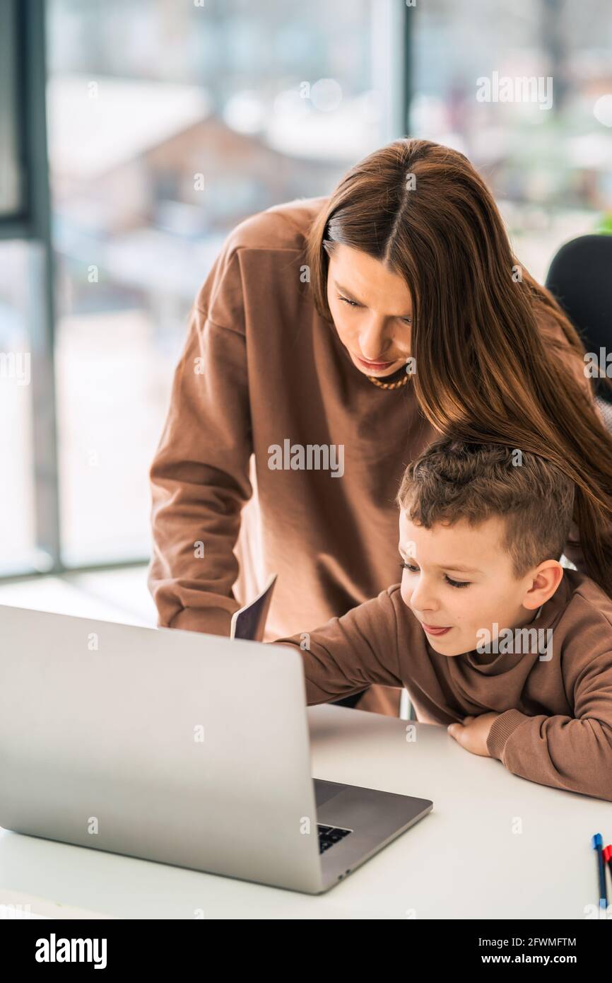 Cute mom and son doing homework at the laptop Stock Photo