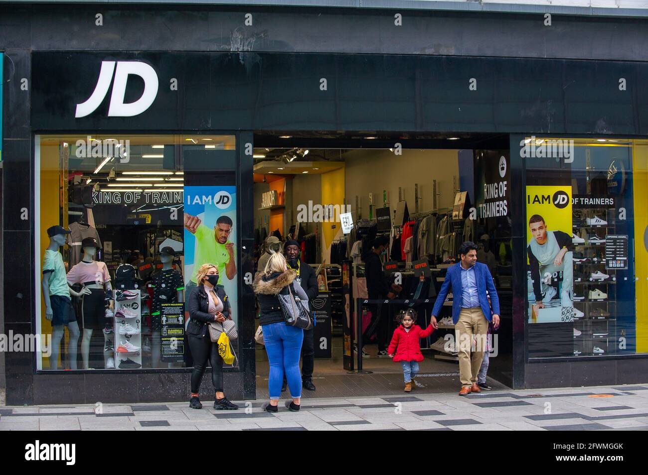 Slough, Berkshire, UK. 23rd May, 2021. Shoppers out in Slough High Street today outside the JD store. The Covid-19 seven day rolling infection rates per 100,000 people in Slough for the week ending May 18 has risen to 25.4, up from 22.7. Given that the number of positive Covid-19 Indian variant cases are starting to rise, the possibly of the entire lifting of lockdown restrictions in June may now be in jeopardy. Credit: Maureen McLean/Alamy Live News Stock Photo
