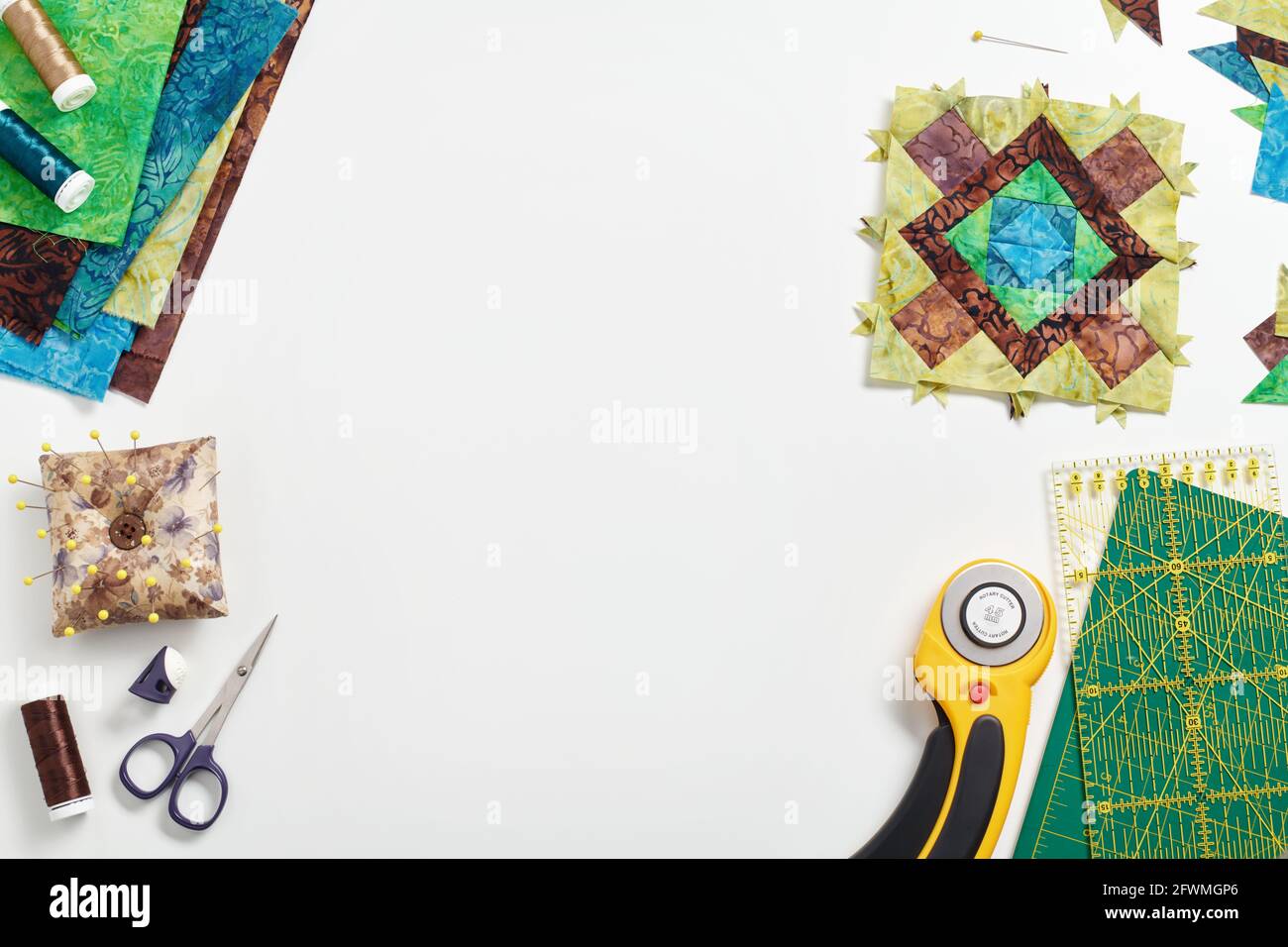 Patchwork block, stack of fabrics, sewing and quilting accessories