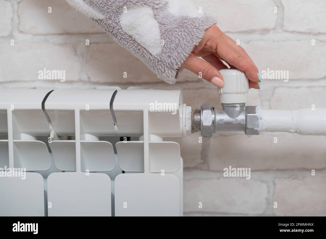 The woman opens the valve of the radiator heating Stock Photo - Alamy