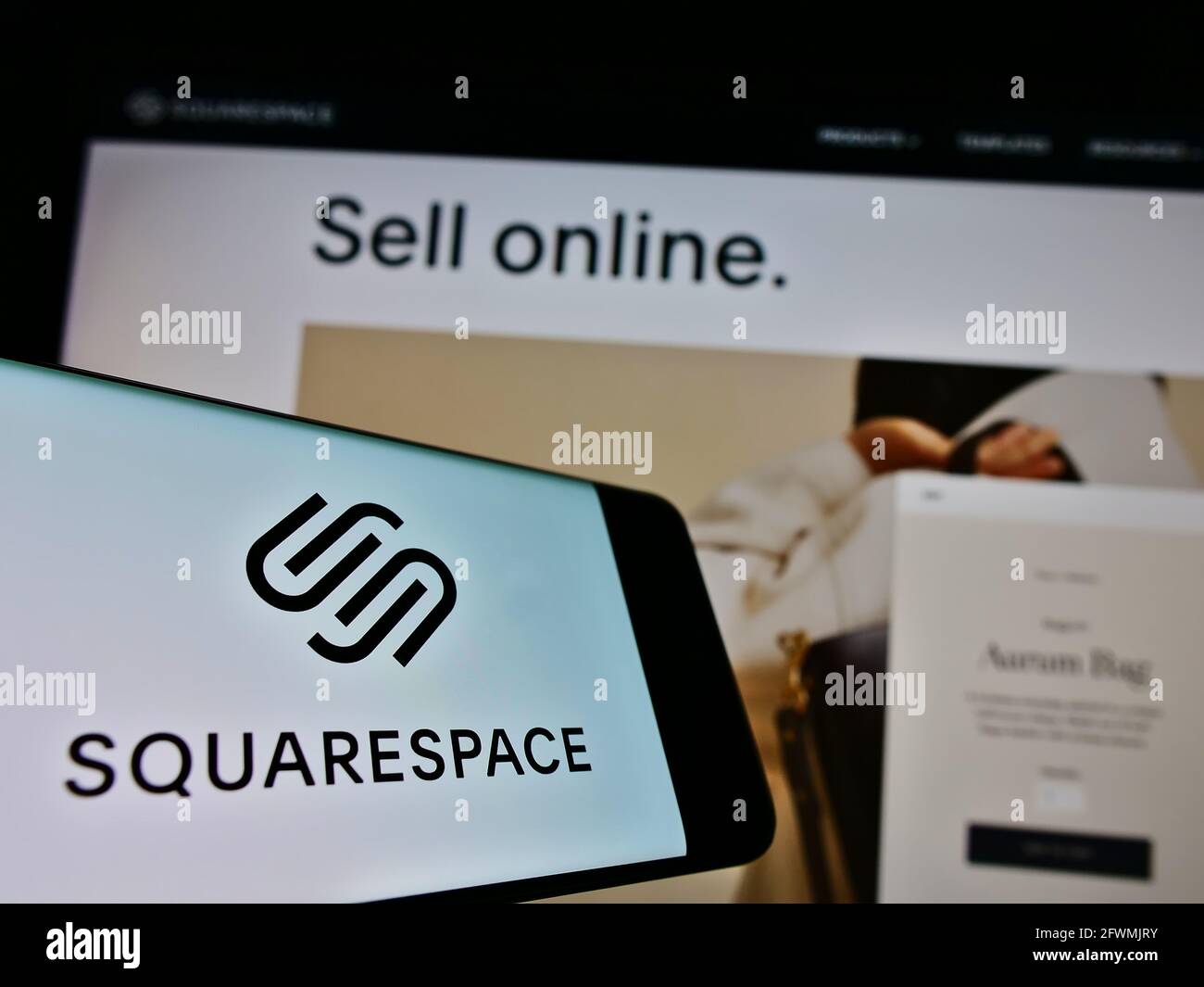 Smartphone with logo of American hosting platform company Squarespace Inc. on screen in front of website. Focus on center-right of phone display. Stock Photo