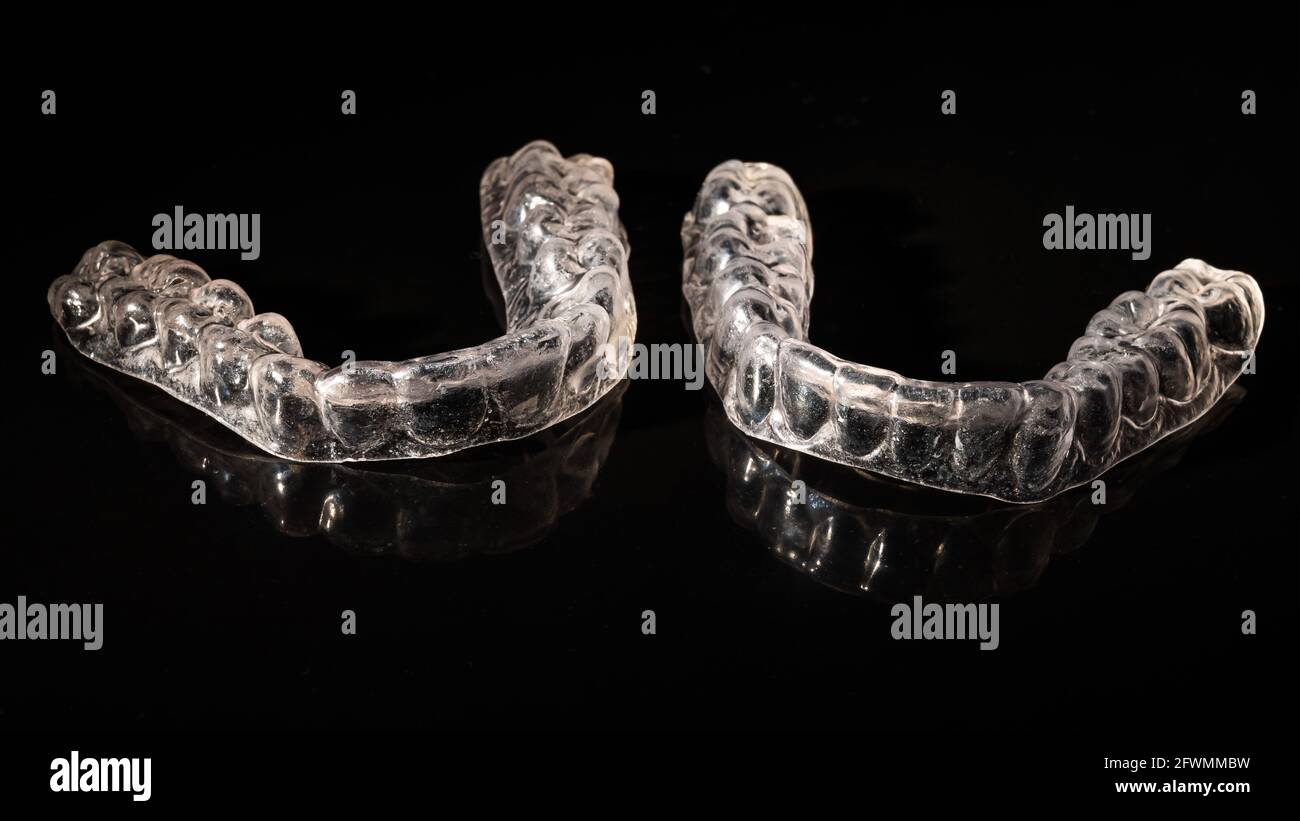 Removable plastic retainers for bite correction on a black background