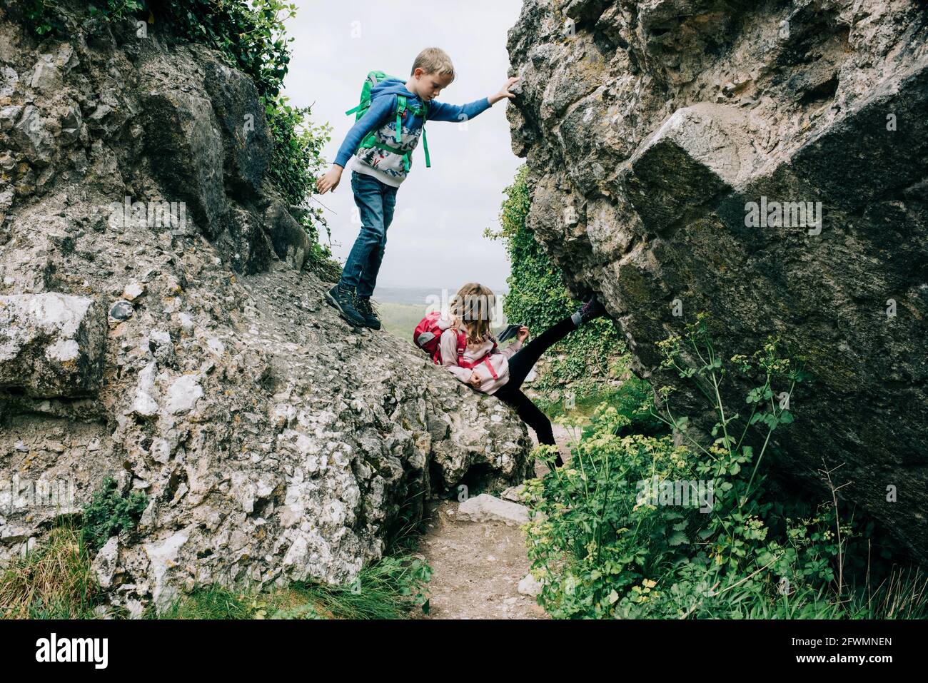 kids climbing on rocks at Corfe Castle exploring the countryside Stock Photo