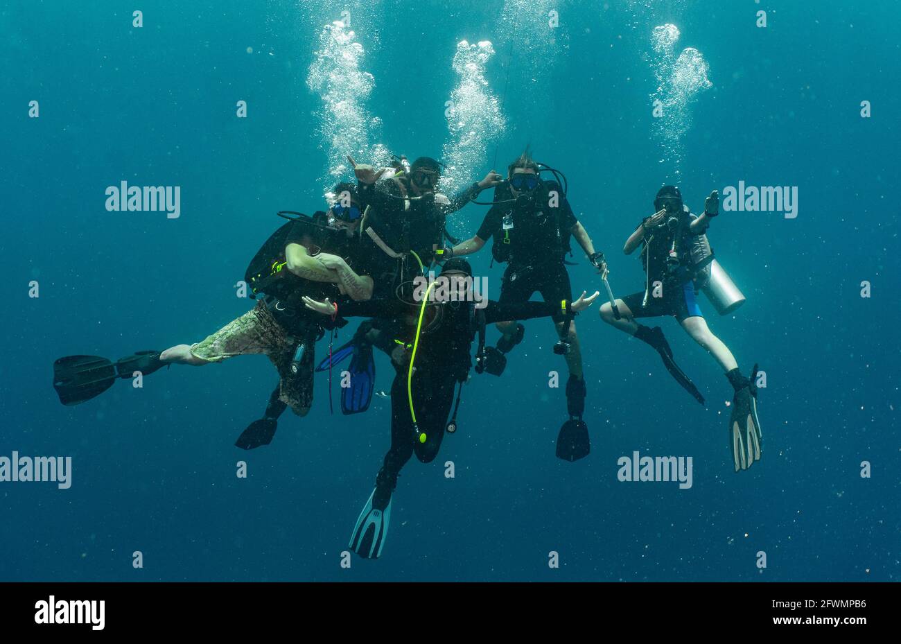 group of divers performing the mandatory safety stop while ascending