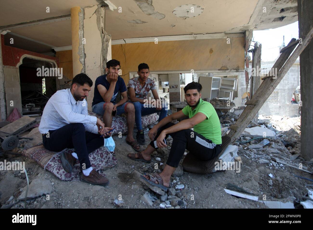 Gaza, Gaza. 23rd May, 2021. Palestinians sit on their homes, destroyed by Israeli strikes, in Beit Hanun in the northern Gaza Strip on Sunday, May 23, 2021. Gazans tried to piece back their lives, after a devastating 11-day conflict with Israel that killed more than 240 people and made thousands homeless in the impoverished Palestinian enclave. Photo by Ismael Mohamad/UPI Credit: UPI/Alamy Live News Stock Photo