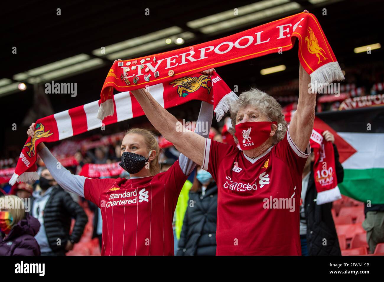 Liverpool. 24th May, 2021. An 89-year-old Liverpool supporter (R) sings 'You'll Never Walk Alone' before the Premier League match between Liverpool and Crystal Palace at Anfield in Liverpool, Britain, on May 23, 2021. Credit: Xinhua/Alamy Live News Stock Photo