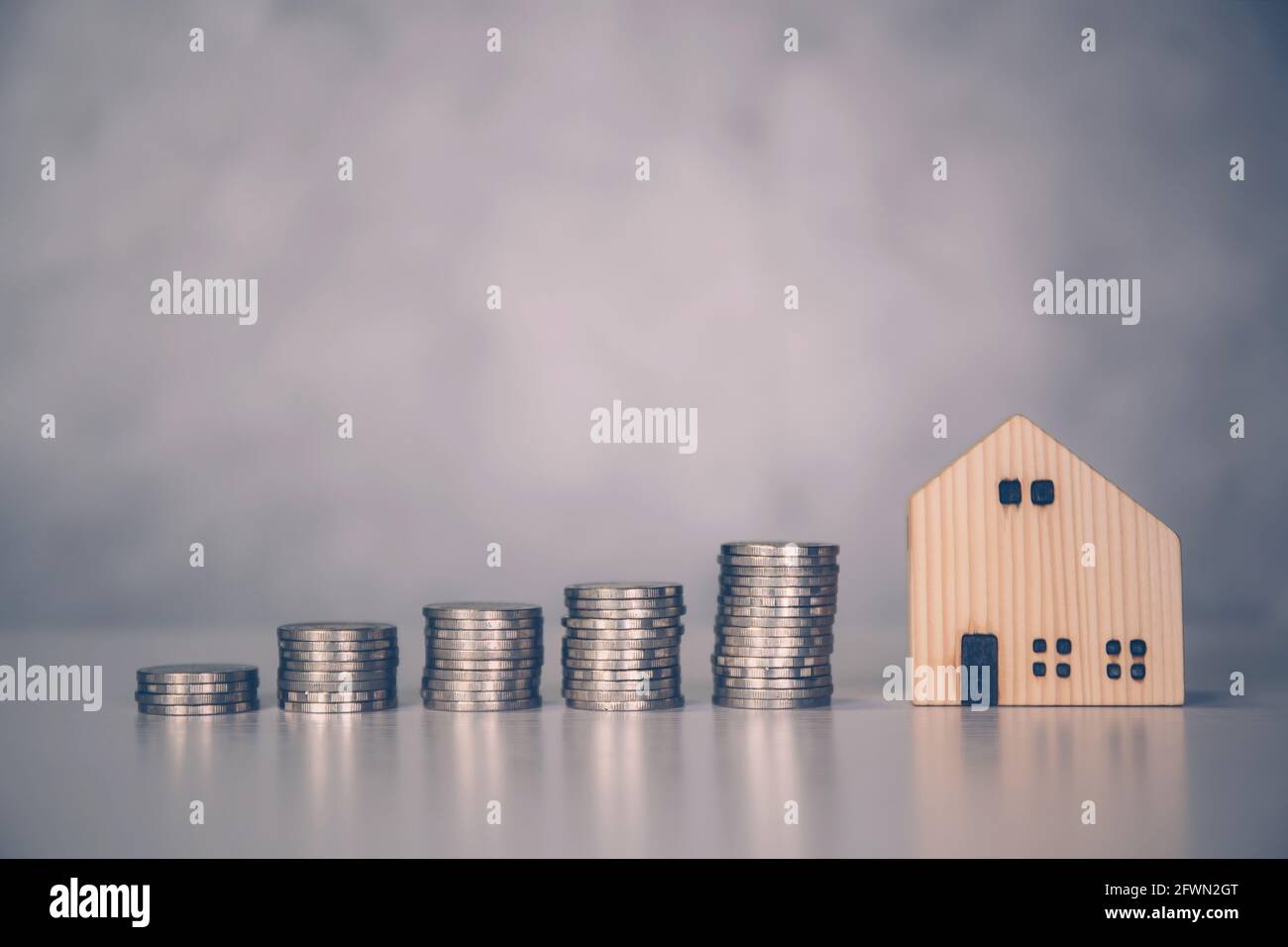 Stack of coin with revenue and saving money for real estate and success, finance and investment, insurance home, deposit and property and financial, r Stock Photo