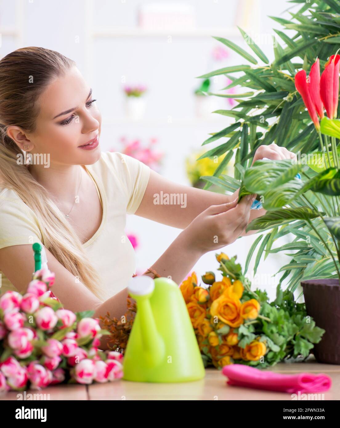 The young woman watering plants in her garden Stock Photo - Alamy