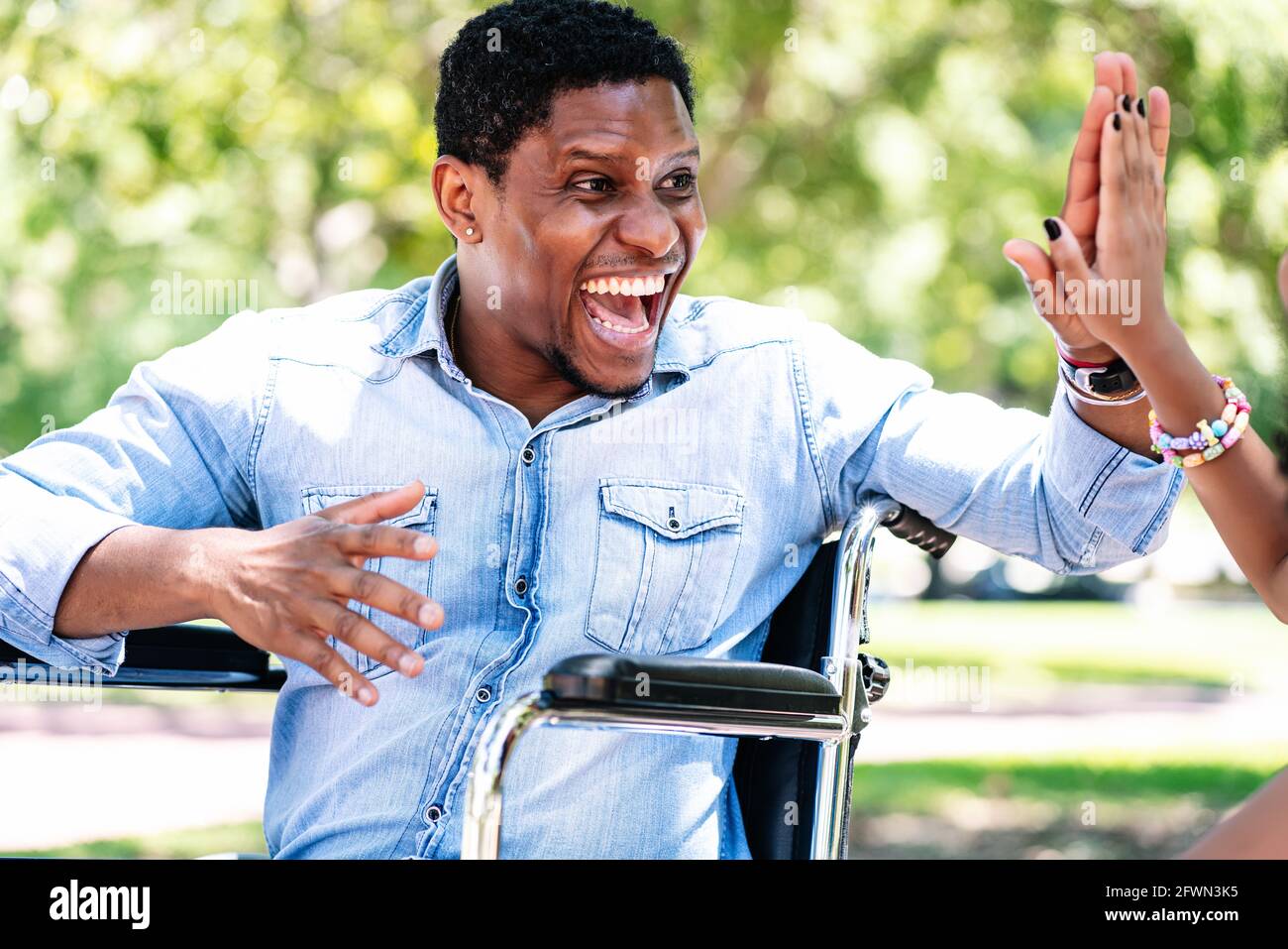 Man in a wheelchair at the park with his daughter Stock Photo - Alamy