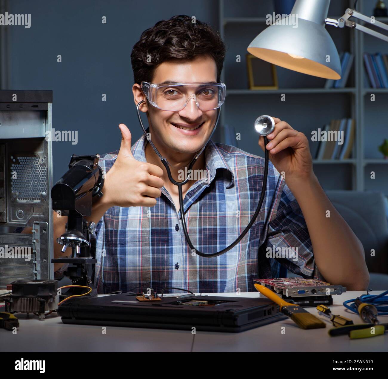 The computer repair concept with man inspecting with stethoscope Stock