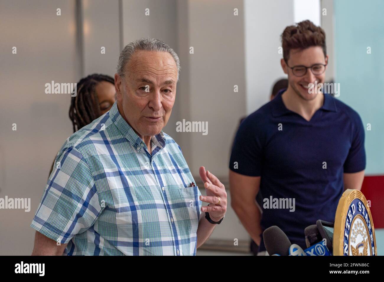 Senate Majority Leader Chuck Schumer (D-NY) speaks at a press conference in  New York City.Standing with Huge Ma, who created the TurboVax Twitter bot,  YouTube's Dr. Mike Varshavski, who has reached millions