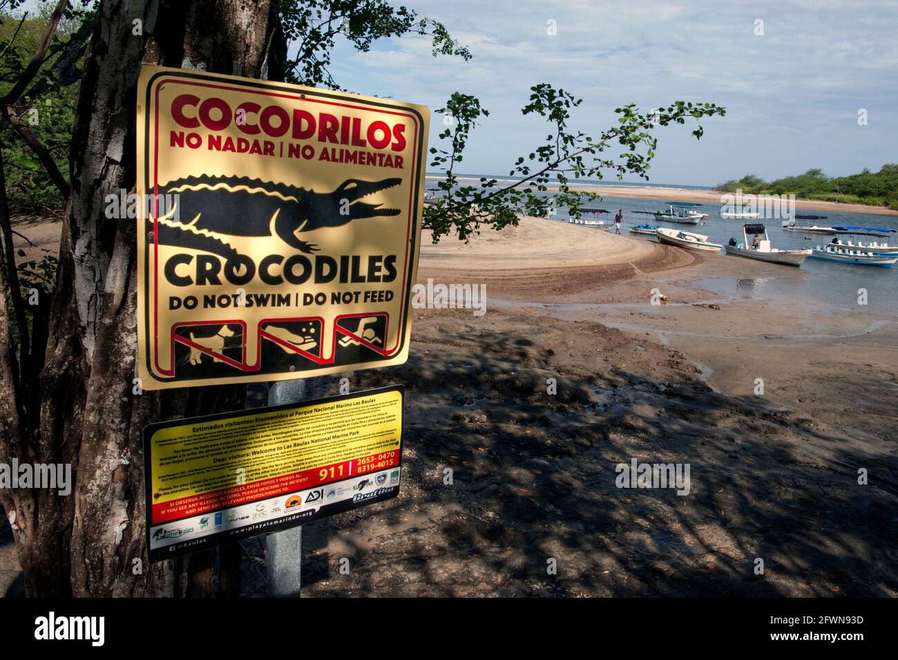 Sign warning of danger from crocodiles at the entry to the Marine National Park at Tamarindo, Costa Rica Stock Photo