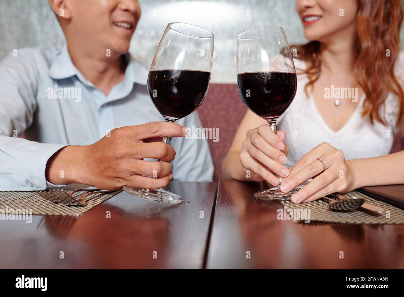 Young couple in love drinking red wine as aperitif when waiting for order in restaurant Stock Photo