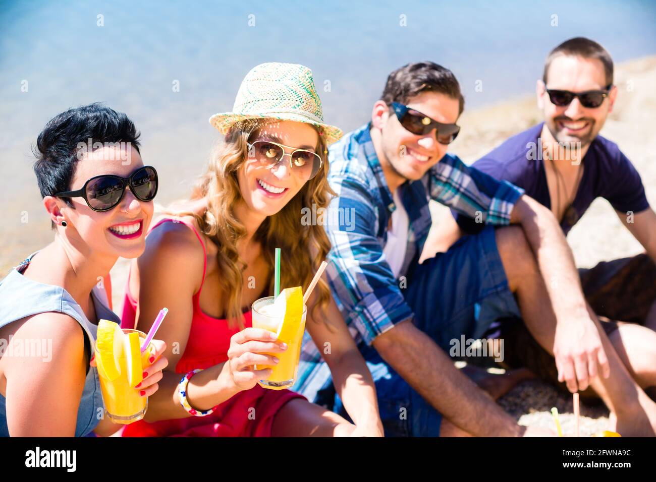 Four women sitting on beach hi-res stock photography and images - Alamy
