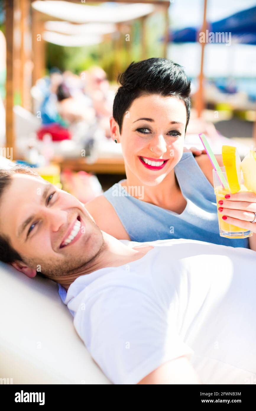 Couple in beach bar relaxing with drinks Stock Photo Alamy